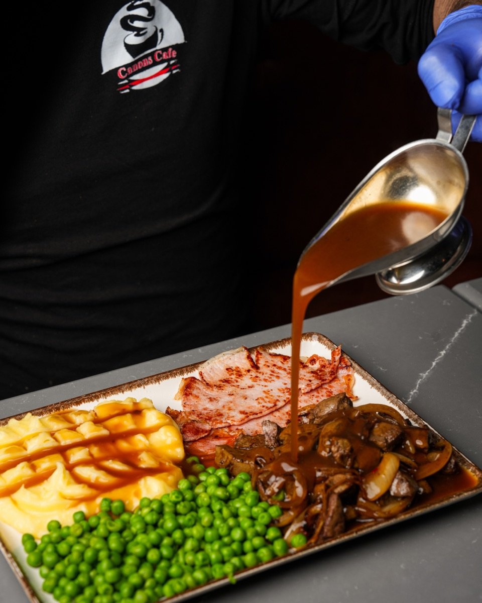 Chef pouring gravy over a home-cooked lunch at Canons Cafe, Edgware